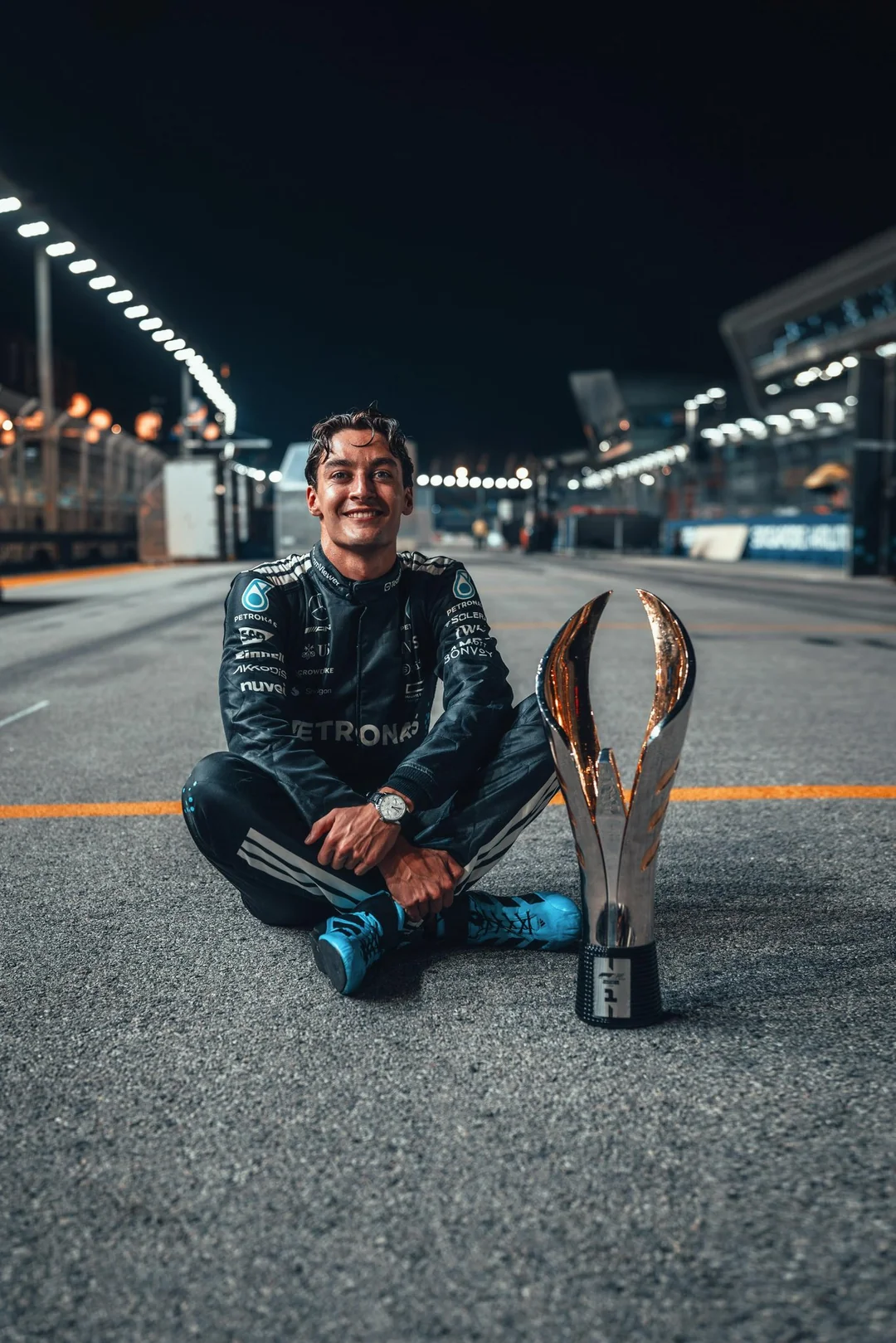 George Russell sitting trackside with his trophy